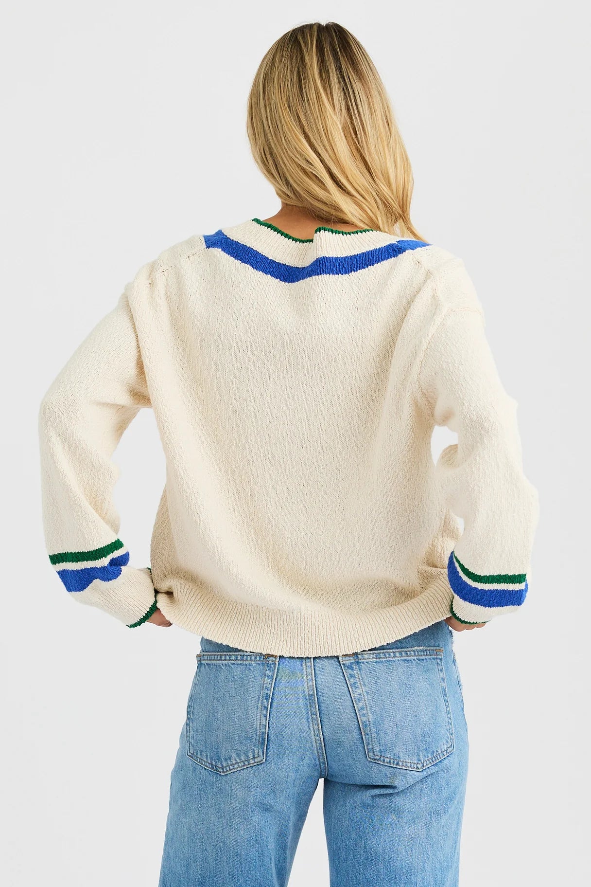 Back view of One Grey Day Venus V-neck sweater with blue and green striped trim, worn with denim jeans.