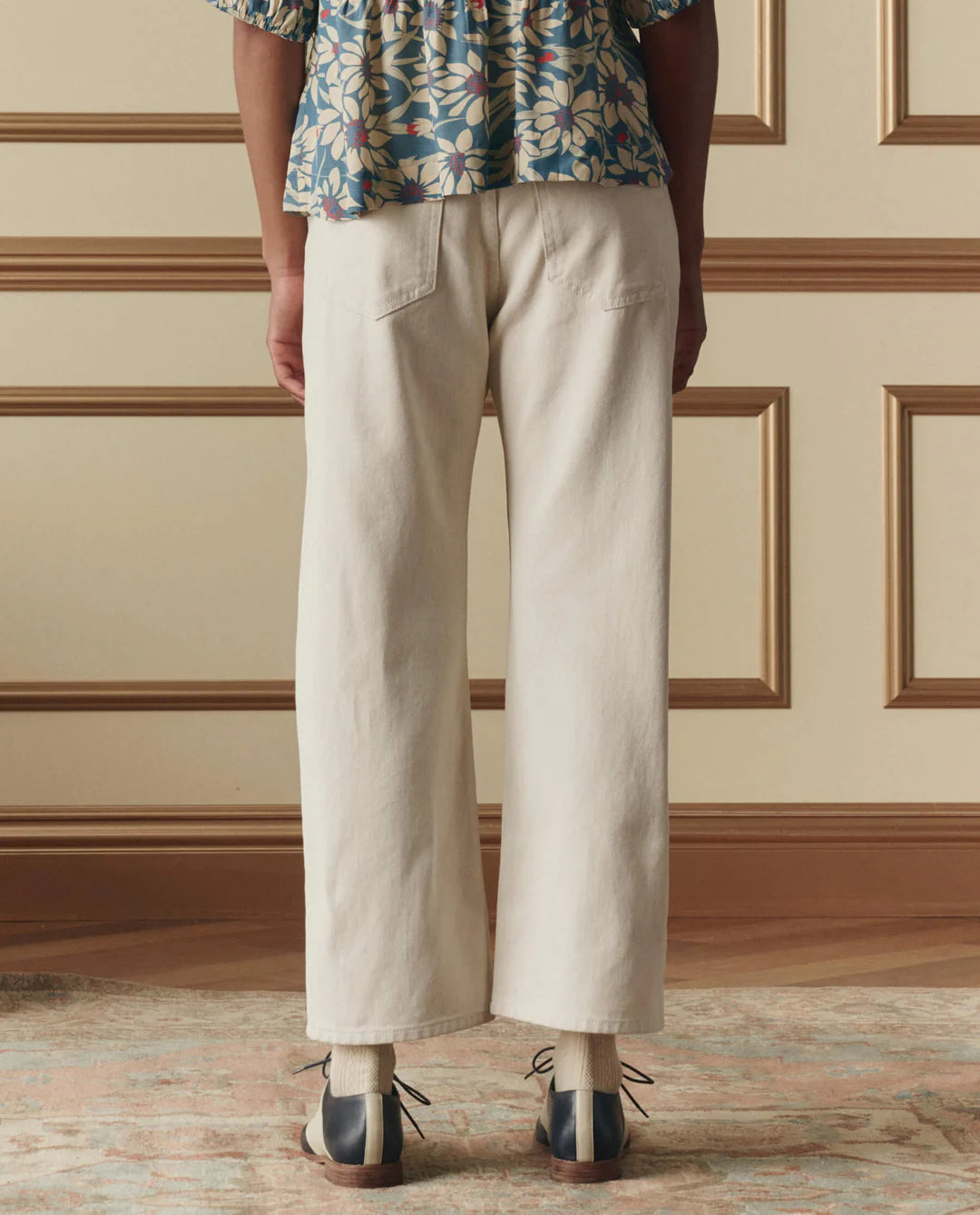 The Great studded Wayne jeans in light wash denim with ankle-length straight-leg fit, shown from behind.